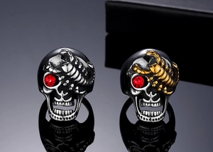 Détail d'une bague tête de mort gothique avec yeux en zircon rouge et gravure de scorpion doré