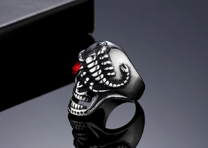Vue macro d'une bague tête de mort gothique avec zircon rouge et scorpion doré