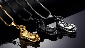 Détail de pendentifs sneakers punk en acier inoxydable or, noir et argenté poli