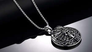 Détail macro du pendentif crâne gothique avec coiffe de plumes sur chaîne acier inoxydable