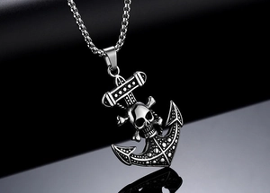 Détail du pendentif crâne ancre en acier titane avec chaîne à maillons sur surface noire
