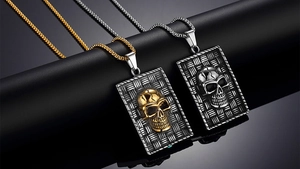 Detail of vintage punk skull rectangle pendants in gold and antique silver finish