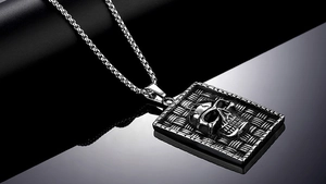 Macro detail of punk rock skull pendant necklace in silver stainless steel with box chain