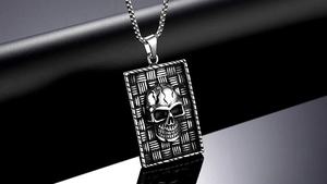 Macro detail of gothic punk skull pendant featuring woven texture and stainless steel finish