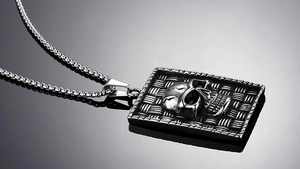 Macro shot of punk style square stainless steel skull pendant with woven texture detail