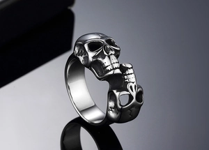 Detailed view of three stacked skulls on a vintage steel ring with gothic punk styling