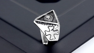 Macro shot of silver punk ring with Eye of Providence and side cross carving
