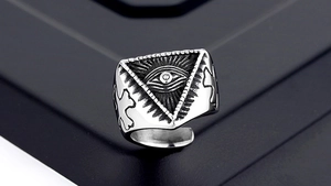 Macro detail of men's vintage silver ring showing the Eye of Providence and side crosses