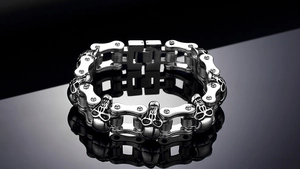 Detalle de pulsera de cadena de moto en acero inoxidable con tallas de calaveras