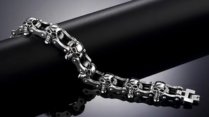 Detalle de pulsera de cadena de moto con calavera de plata vintage en soporte de cuero