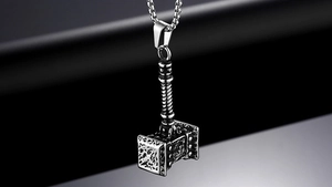 Détail du pendentif Marteau de Thor avec gravures nordiques sur une chaîne en acier