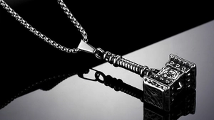 Détail macro du pendentif Mjölnir viking nordique avec relief vintage et chaîne box