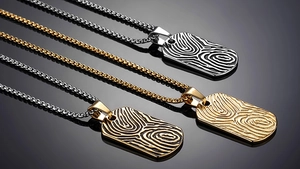 Macro view showing stainless steel dog tag pendants with spiral texture and box chains
