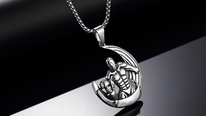 Macro view of dumbbell pendant with muscular figure engraving on stainless steel