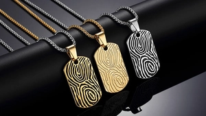 Macro shot of three stainless steel rectangular pendants with textured fingerprint engravings
