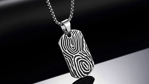 Detailed close-up of textured stainless steel dog tag pendant with unique wood grain etching