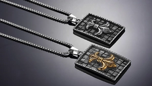 Macro shot of punk cross shield pendants with metallic woven texture and fleur-de-lis icons