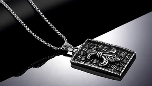Macro shot of vintage shield pendant with fleur-de-lis motif and woven texture