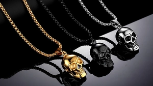 Detailed view of skull pendants in gold, black, and silver finishes with box chains