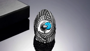 Detailed engraving of vintage eagle head feather ring with turquoise stone inlay