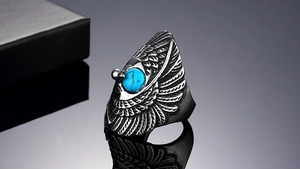 Detailed view of vintage eagle feather ring with turquoise stone inlay on silver metal