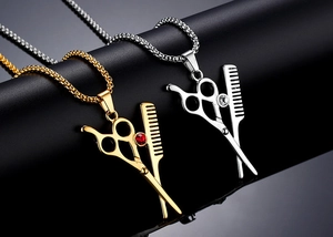 Vue macro des colliers avec pendentifs ciseaux et peigne en finition dorée et argent