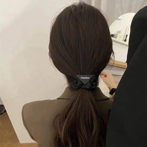 Minimalist black silk scrunchie with fashion triangle charm worn on ponytail