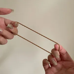 Gros plan d'un élastique cheveux marron montrant sa grande élasticité et sa texture