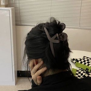 Detail view of large matte dark brown rectangular hair claw clip in a cross design