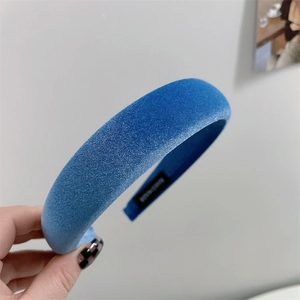 Close-up of blue velvet sponge headband showing woven texture and black non-slip lining