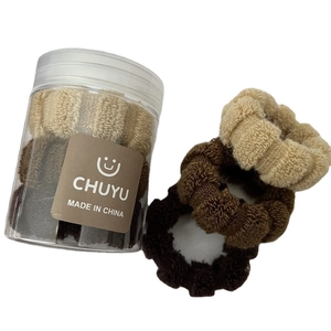 Brown and beige plush scrunchie set in a clear plastic jar for hair styling and accessories