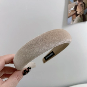 Close-up of a champagne gold velvet sponge headband showing premium satin texture and thickness