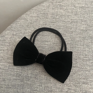 Gros plan détaillé d'un chouchou noeud en velours noir classique avec double élastique