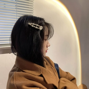 Barrette à cheveux élégante en perles avec pendentif papillon porté sur le côté des cheveux