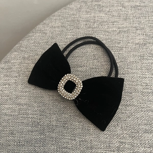 Détail d'un chouchou en velours noir orné d'un cristal rectangulaire brillant