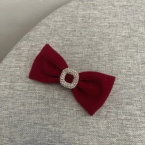 Gros plan sur le nœud en velours bordeaux avec boucle carrée en strass scintillants