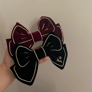 Elegant velvet bow hair clips in red and black with pearl chain trim and metal logo