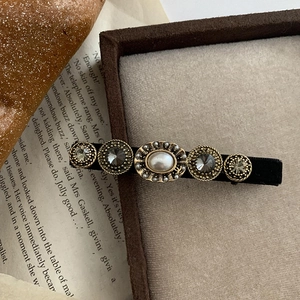 Pinza de pelo barroca vintage con perlas y pedrería sobre base de terciopelo negro