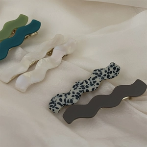Barrettes à cheveux ondulées en acétate en cinq couleurs sur fond de soie