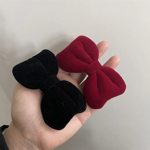 Elegant velvet bow hair clips in red and black colors with a classic vintage aesthetic