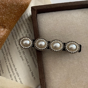 Detalle del pasador barroco vintage con cuatro perlas de imitación y brillantes cristales