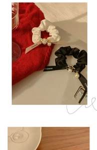 Detailed close-up of elegant satin scrunchies with camellia flowers and pearl charms