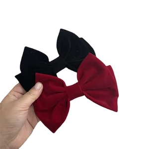 Elegant pair of velvet bow hair clips in red and black with sophisticated vintage texture
