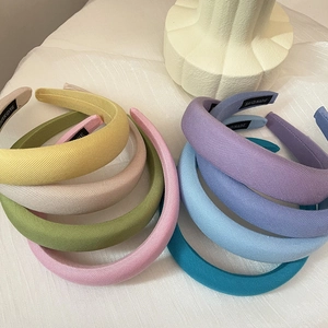 Detailed macro view of multi-colored padded headbands with handmade woven labels
