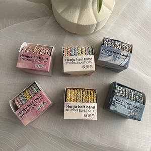 Set of ten colorful elastic braided hair ties in assorted pastel tones in a gift box