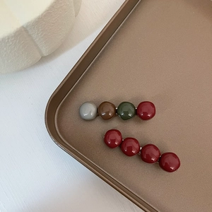Retro hair clips with colorful glazed beads on a brown tray in a minimalist style