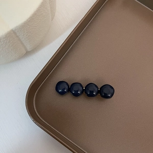 Close-up of vintage hair clip with dark blue spheres on a gold-tone metal base