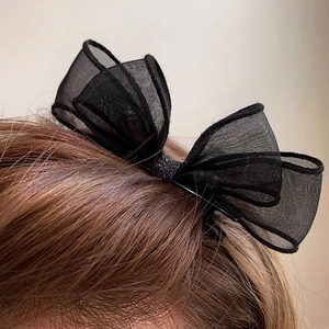 Détail d'une pince à cheveux avec nœud en tulle noir à double épaisseur délicate