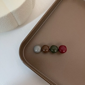 Detail of vintage retro hair clip with colorful glossy beads on a metallic tray