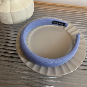 Detail showing handmade fabric label on the lavender sponge headband with soft texture